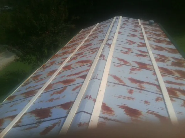 Rusted metal roof panels with new wood purlins before replacement — Storm Damage Roof Repair in Wayland by Roofing Brothers